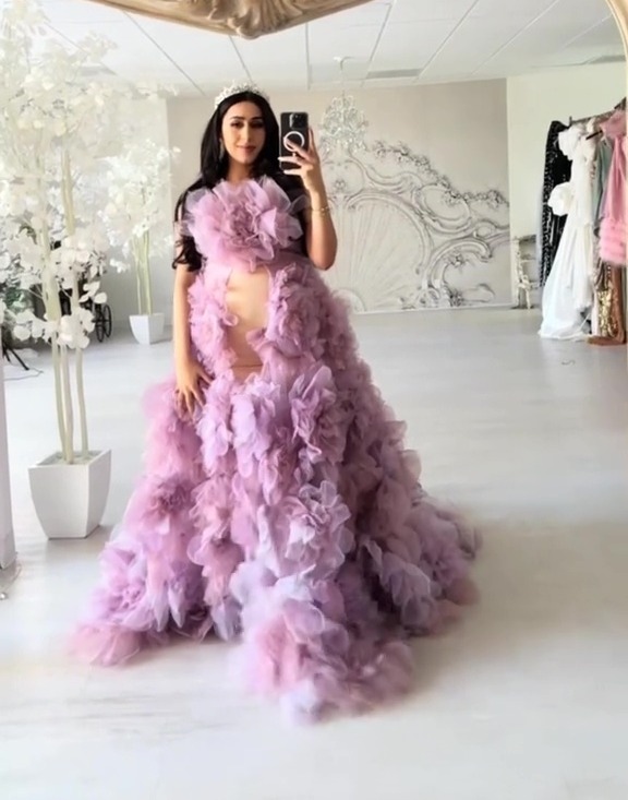 Pregnant woman in a lavender tulle gown taking a selfie.