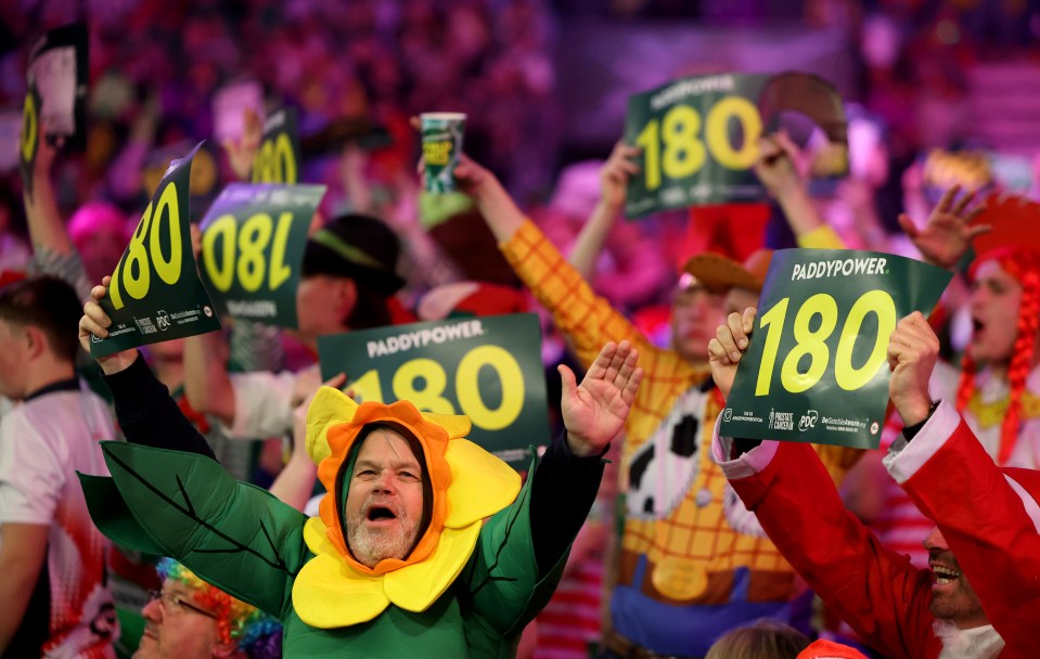 Darts fans celebrating at a tournament.