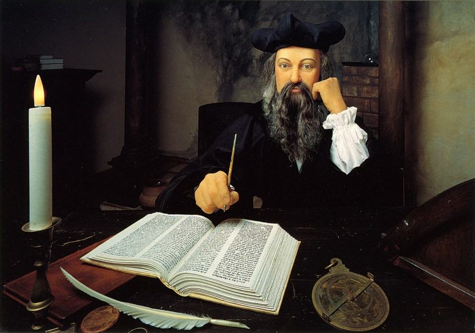 Michel de Nostradamus at his desk, writing in a large book.