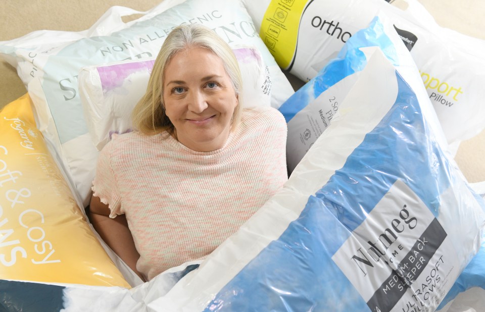 Woman surrounded by pillows in plastic packaging.