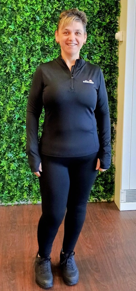 Woman in black athletic wear after weight loss.