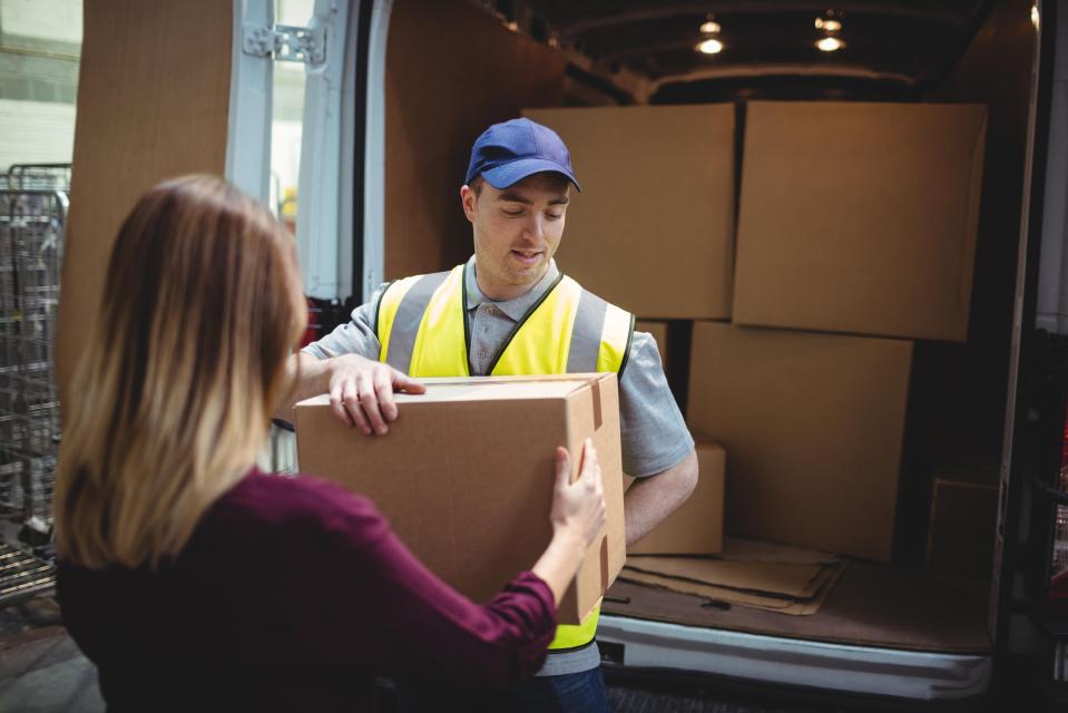 Delivery driver handing a parcel to a customer.