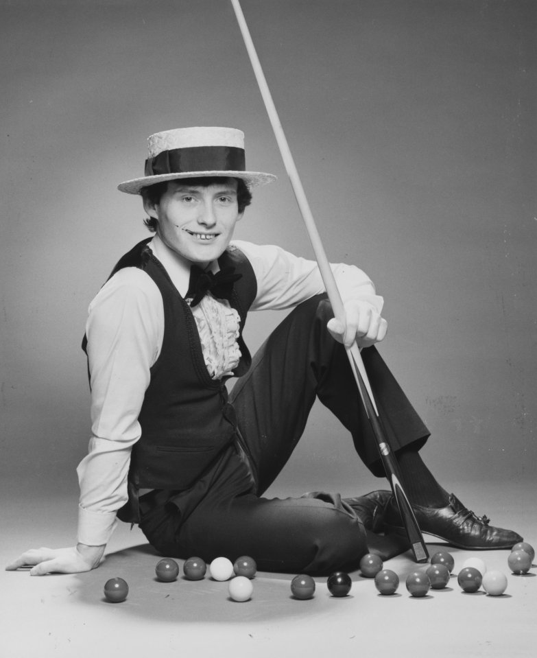 Jimmy White, snooker player, seated with cue and snooker balls.