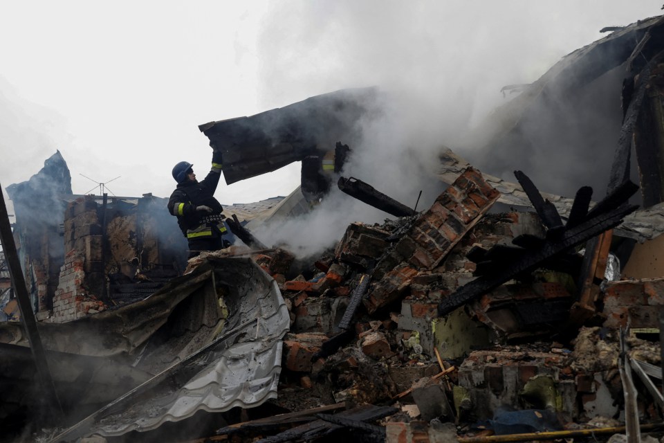 Firefighters work at the site of residential buildings hit by a Russian drone strike in Kharkiv