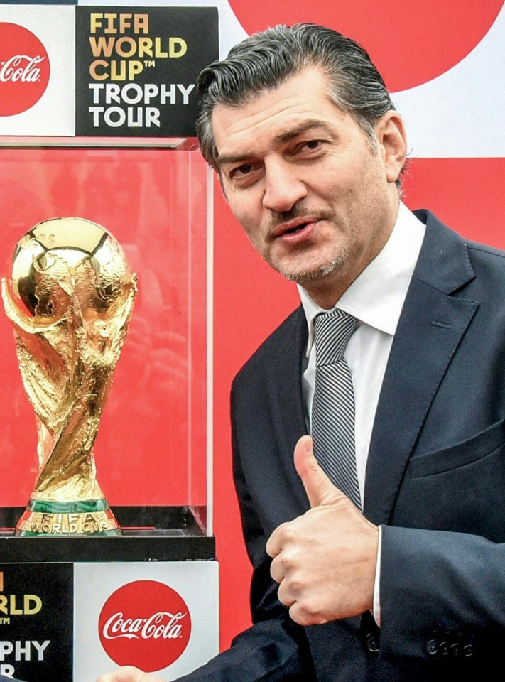 Kavelashvili poses in front of the FIFA world cup trophy during its world tour, at a ceremony in Tbilisi in 2018