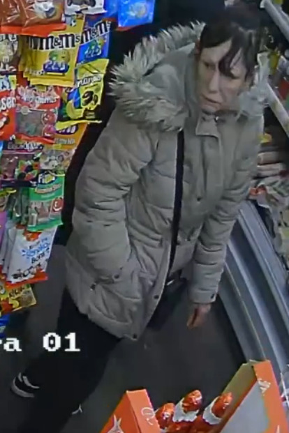 CCTV image of a missing woman in a light grey coat.