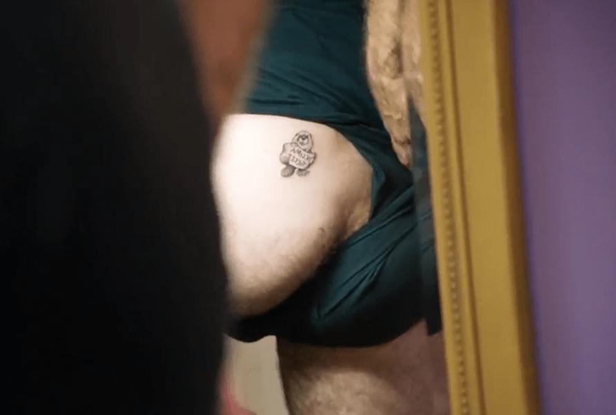 Person's butt with a small tattoo.