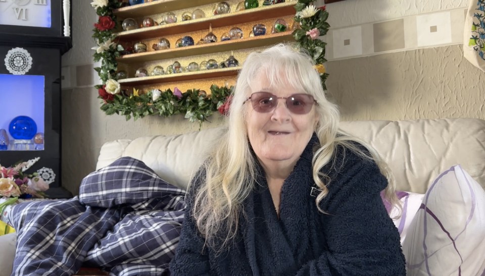 Glenda Kenyon, a 71-year-old woman, sits on her sofa surrounded by Gavin & Stacey memorabilia.