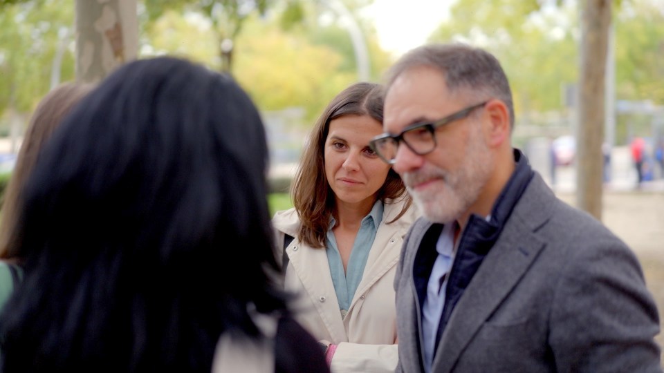 Three people talking outdoors.