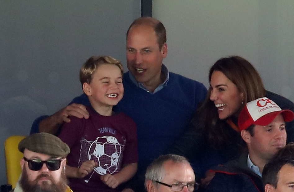 Prince William, Kate Middleton, and Prince George at a soccer game.