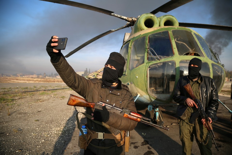 Insurgents take selfies at the Nayrab military airport, in Aleppo, during the offensive