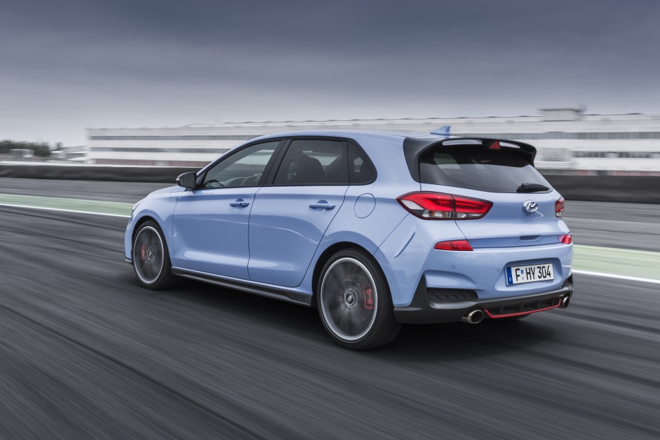 A light blue Hyundai i30N driving on a race track.