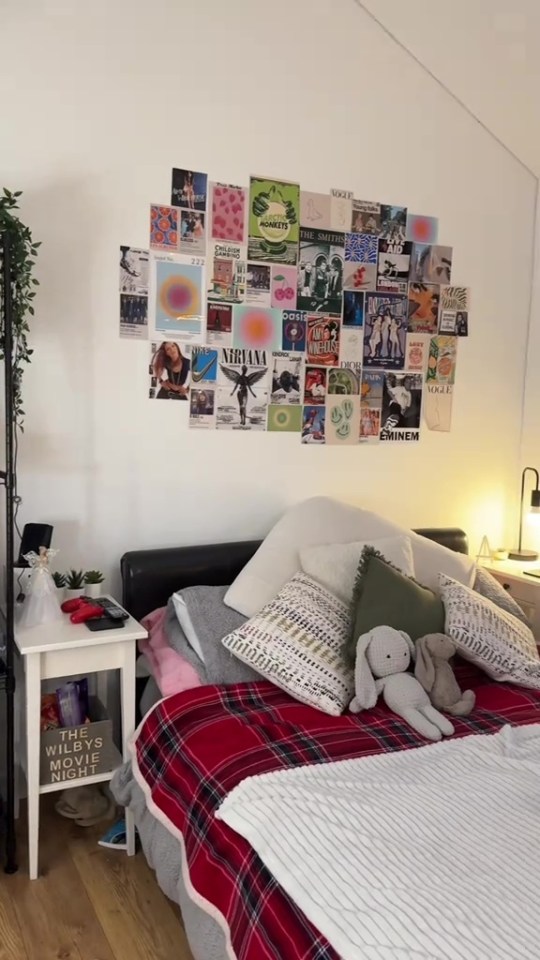 A bedroom with a collage of posters above the bed.