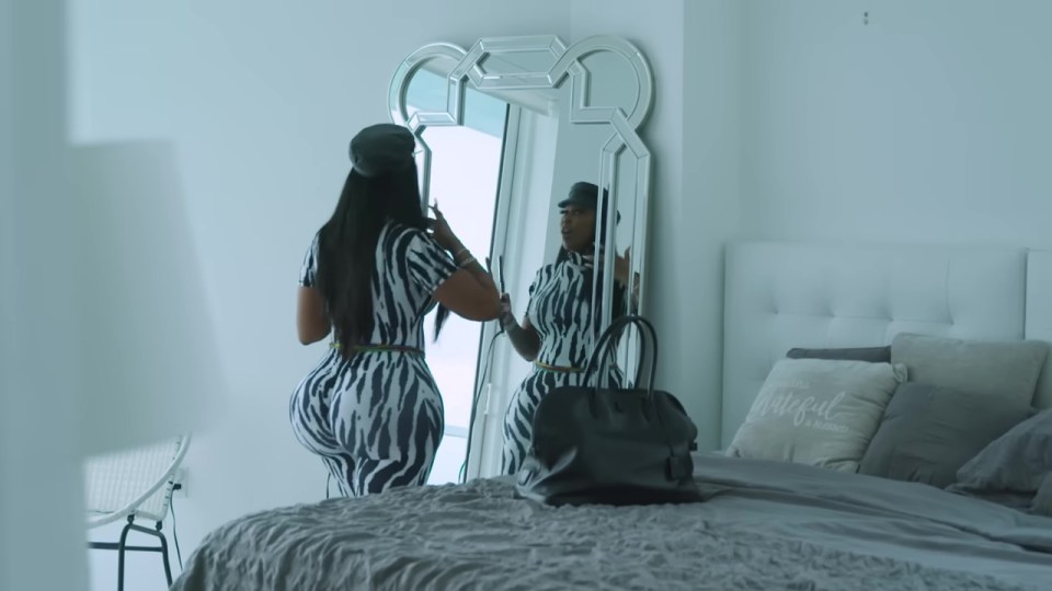 Woman in zebra-print outfit looking in a mirror.