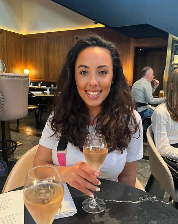 Woman holding a glass of champagne in a restaurant.