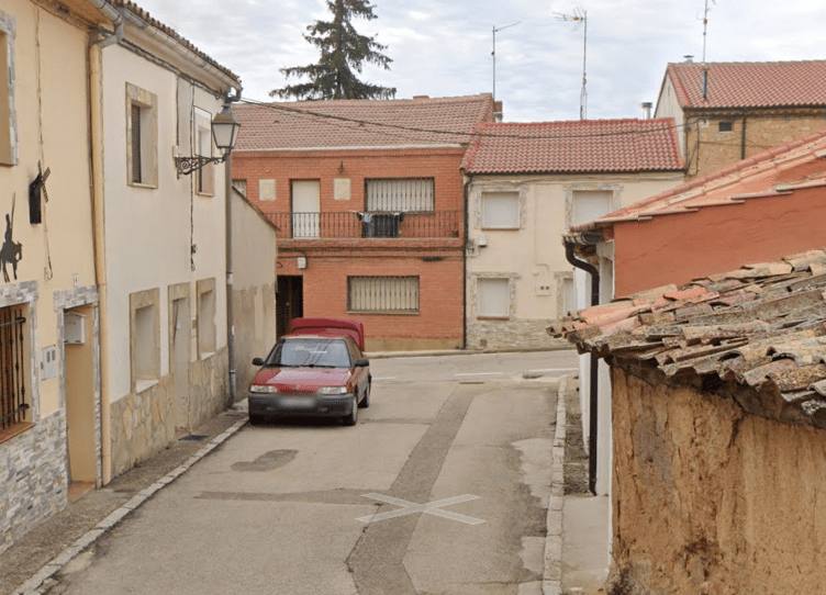 The red car with an open boot on a deserted street