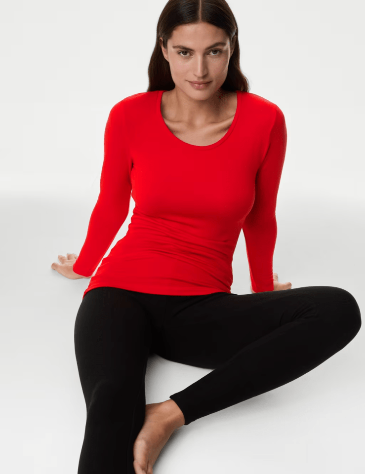 Woman in red long-sleeve shirt and black leggings.