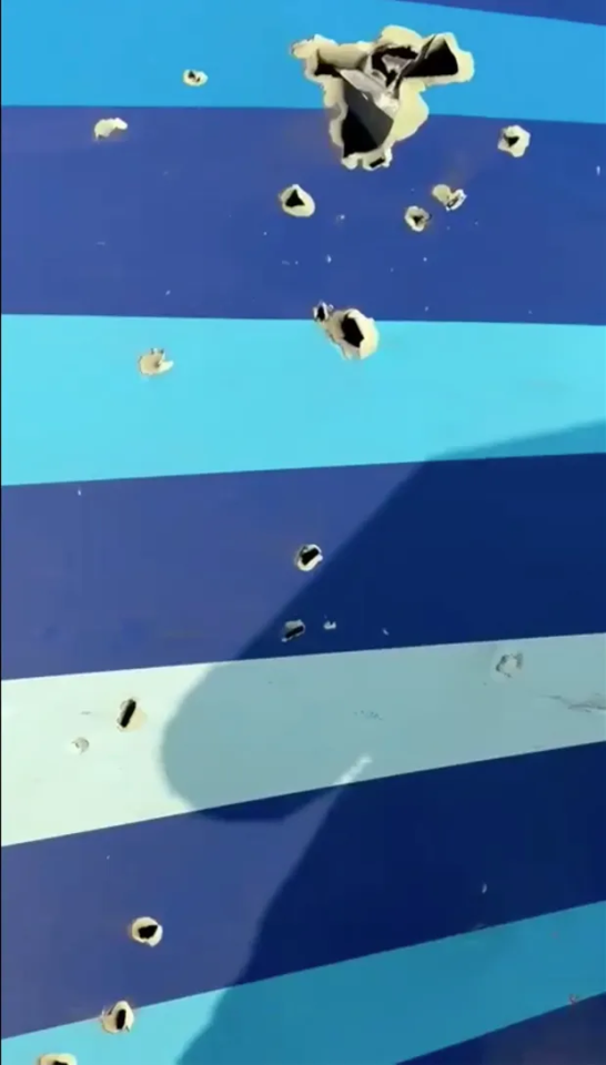 Bullet holes in a blue and light blue striped surface.