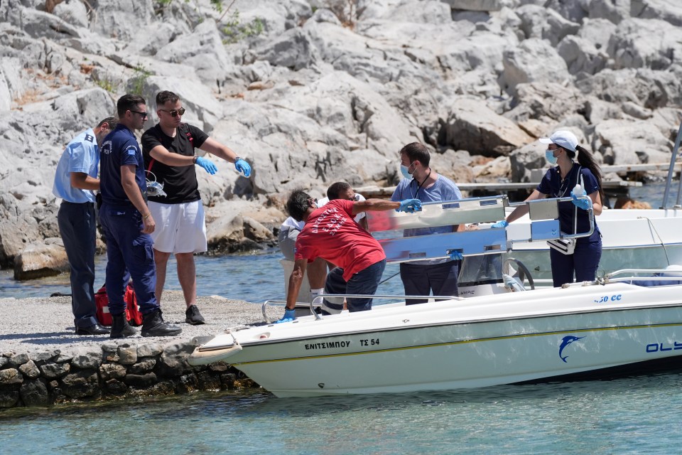 Emergency personnel loading a stretcher onto a boat.