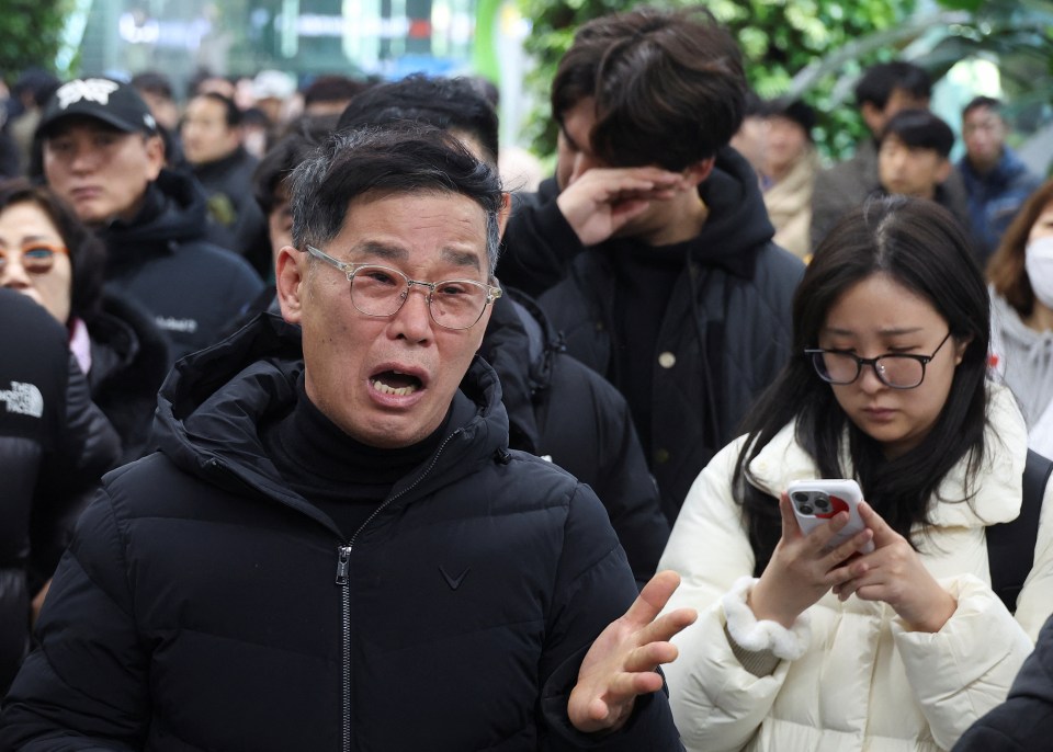 A man speaking passionately in a crowd.