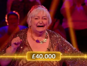 A joyful woman wearing a sparkly dress and crown celebrates winning £40,000.