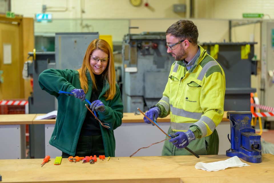 Two people working with wires in a training center.