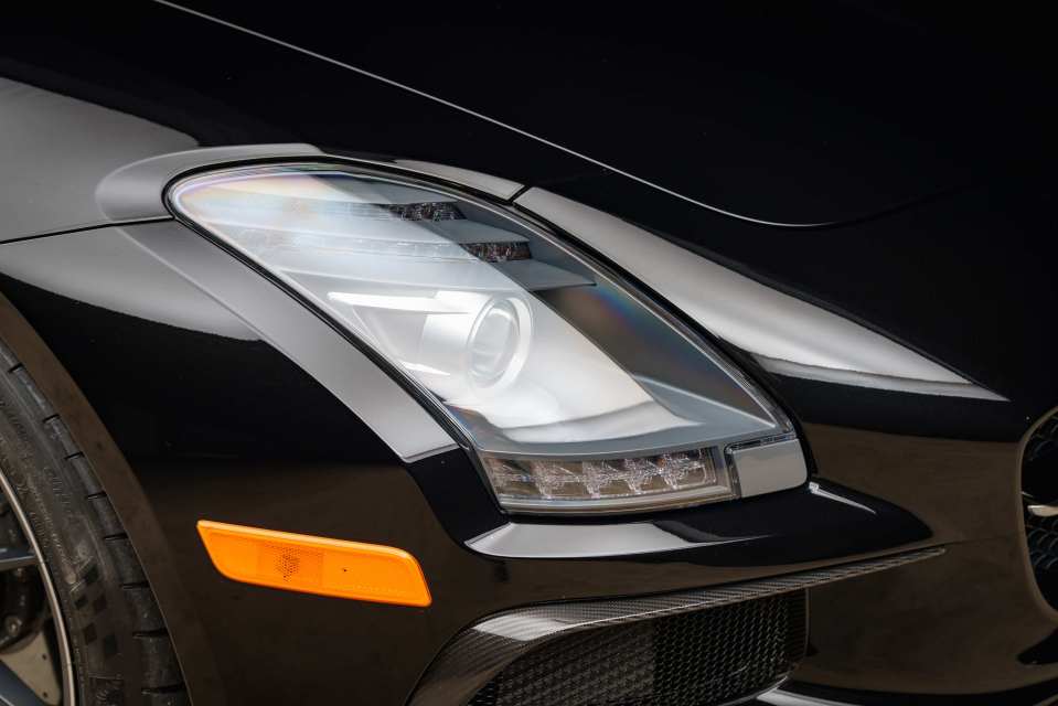 Close-up of a black Mercedes-Benz SLS AMG Black Series headlight.