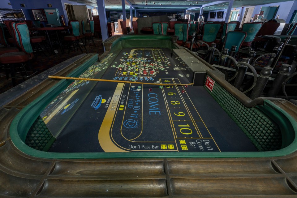 Abandoned craps table with chips and dice.