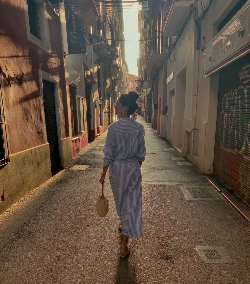 Woman walking down a narrow street in Mallorca.