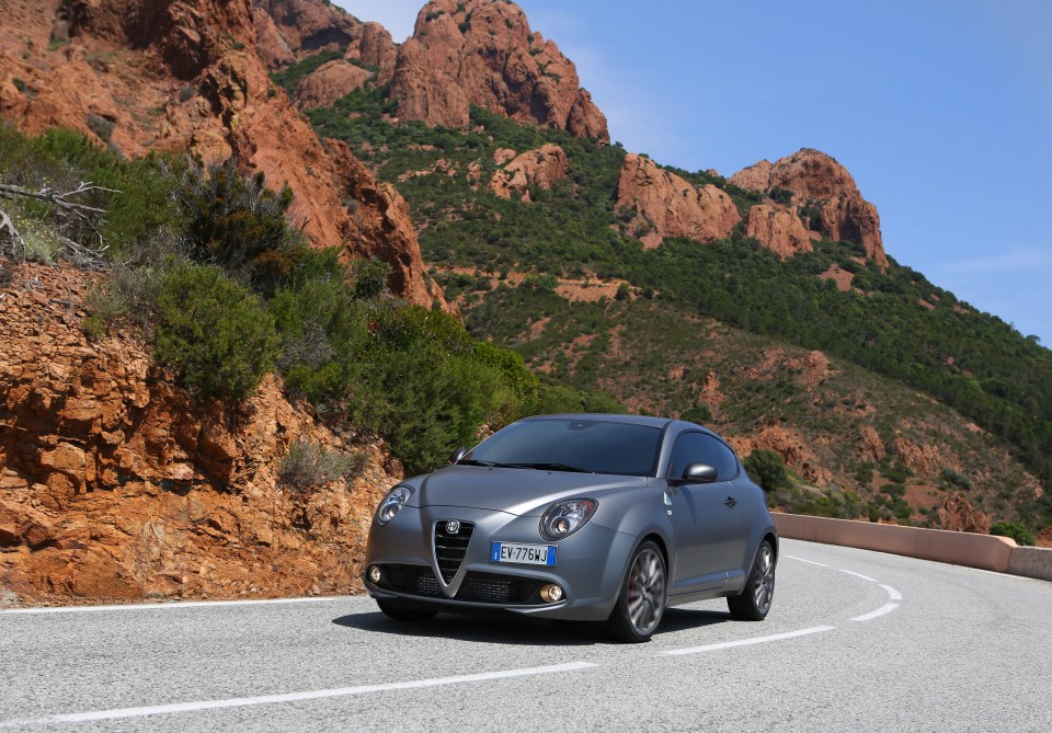 Alfa Romeo Mito Quadrifoglio Verde driving on a mountain road.