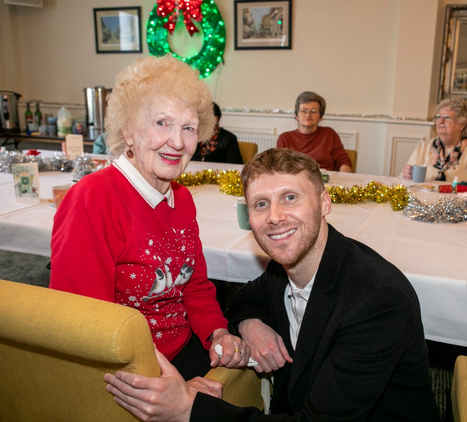 Actor Jamie Borthwick with a senior at a Christmas party for Age UK.