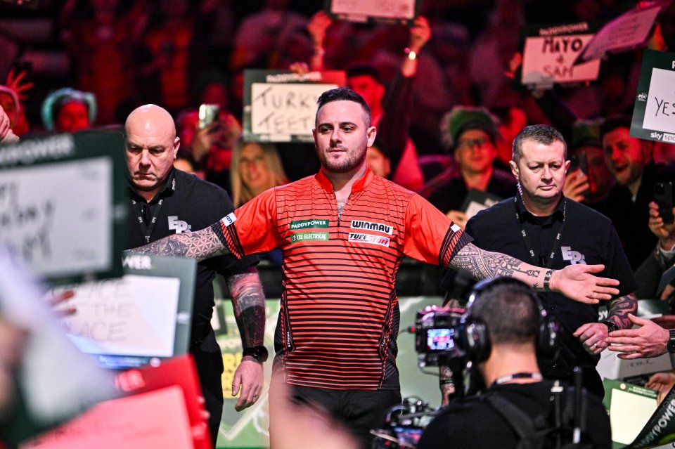 Joe Cullen greets fans before a darts match.