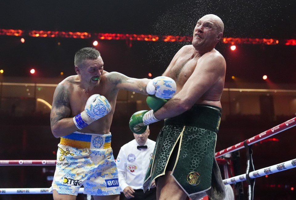 Oleksandr Usyk landing a punch on Tyson Fury during a boxing match.