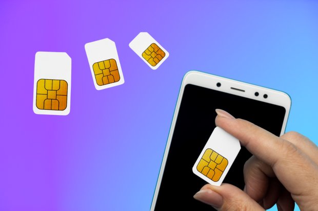 Hand inserting SIM card into smartphone.