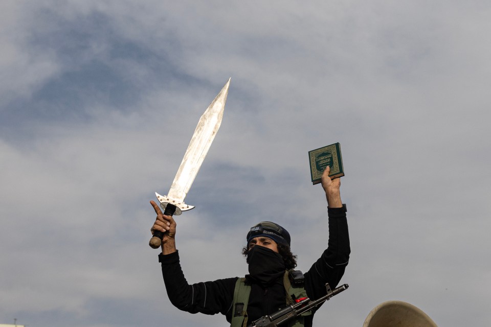 A fighter in Hama celebrates the capture of the city