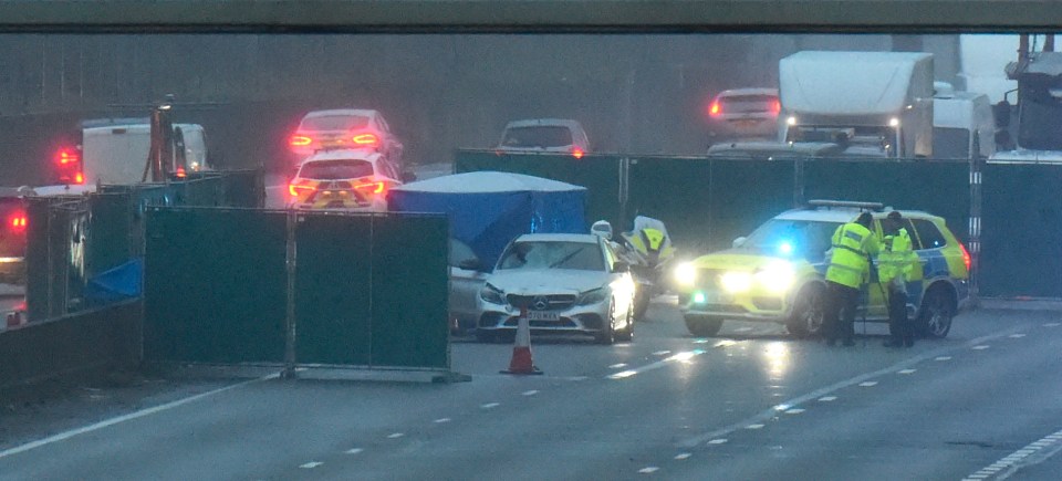 Police officers at a fatal M25 motorway accident scene.