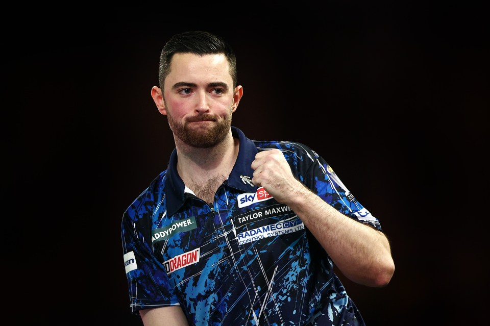 Luke Humphries of England celebrates during a darts match.