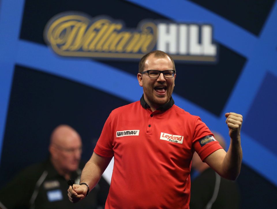 Mark Webster celebrates a darts match victory.