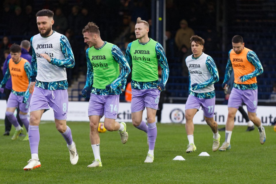 Swansea City's players go through the motions as they warm up for the match