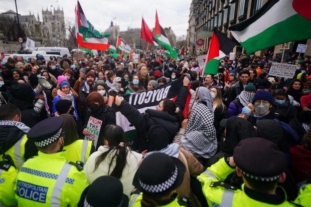 Police officers form a cordon at a Free Palestine Coalition demonstration in London.