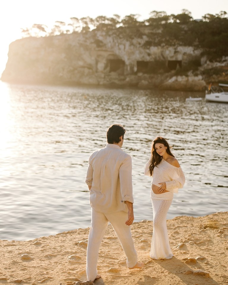 Pregnant Michelle Keegan and her partner on a beach.