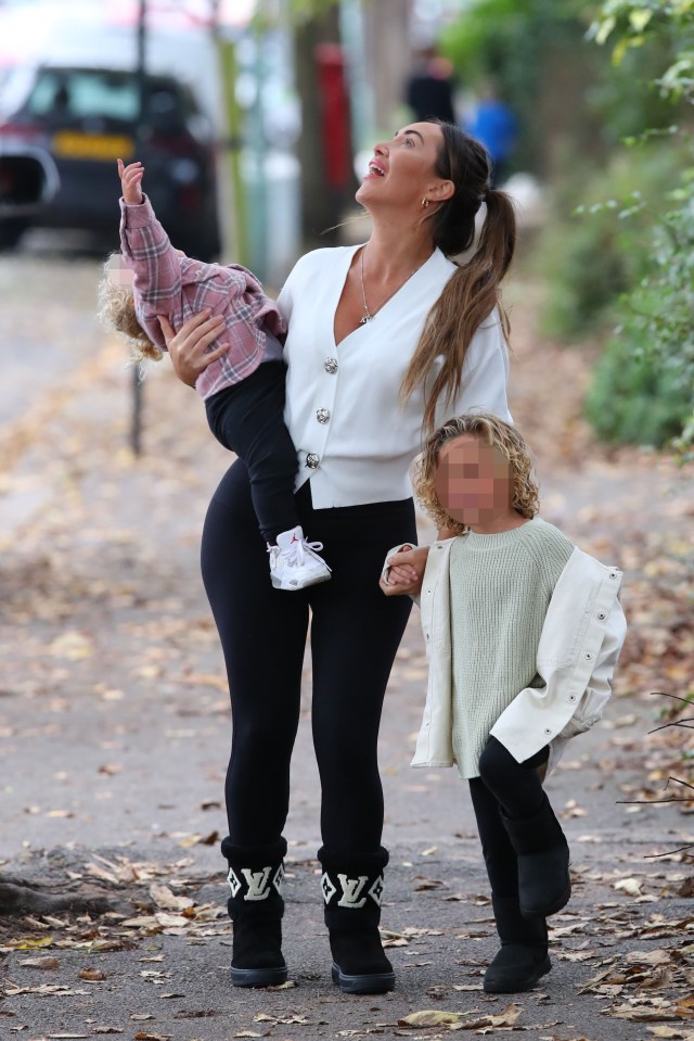 Lauryn Goodman walking with her two children.