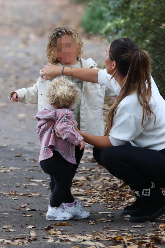 A woman with two young children on a walk.