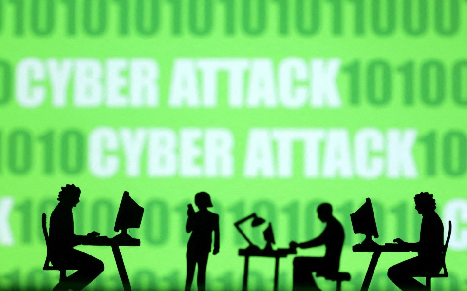 Silhouettes of people working at computers against a background of binary code and the words "Cyber Attack."