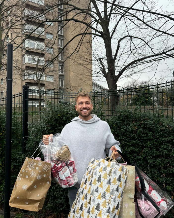 Man carrying multiple Christmas gift bags.