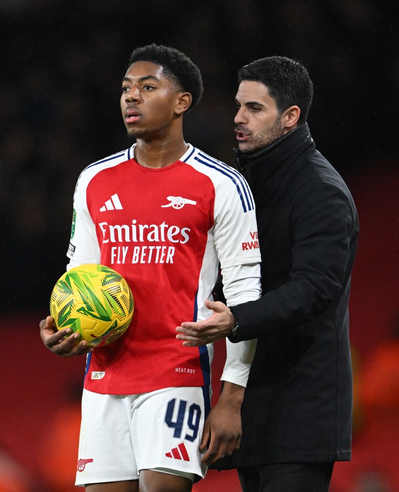 Myles Lewis-Skelly of Arsenal receives instructions from manager Mikel Arteta.