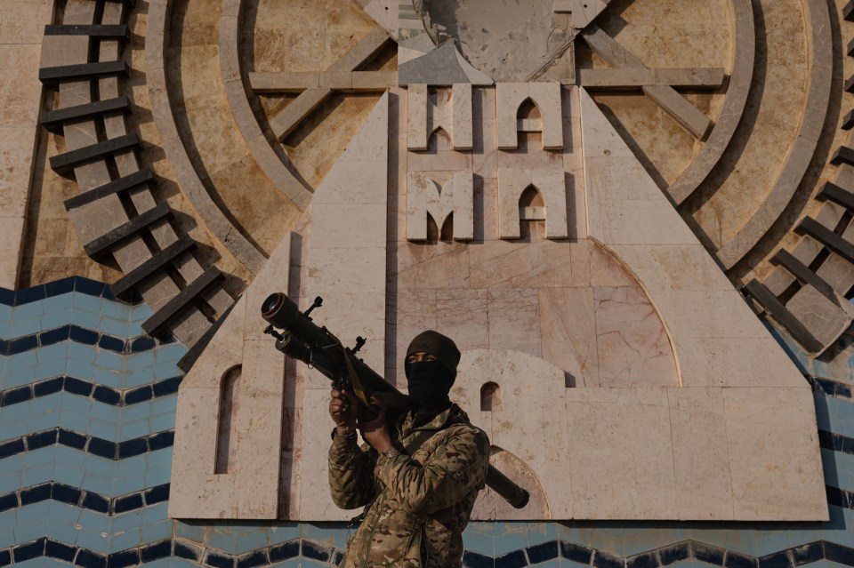 A rebel fighter stands in central Hama after it was captured on Thursday