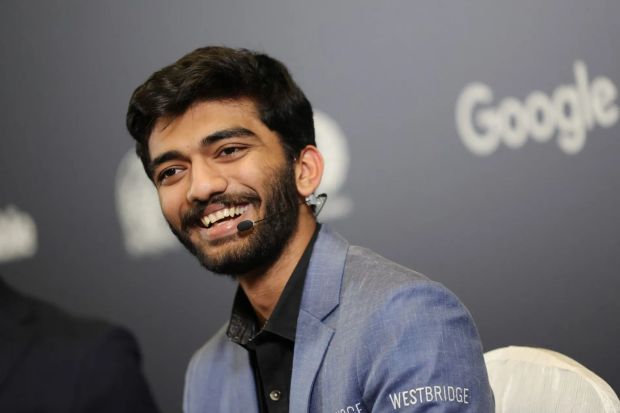 Smiling man wearing a blue blazer and a microphone.