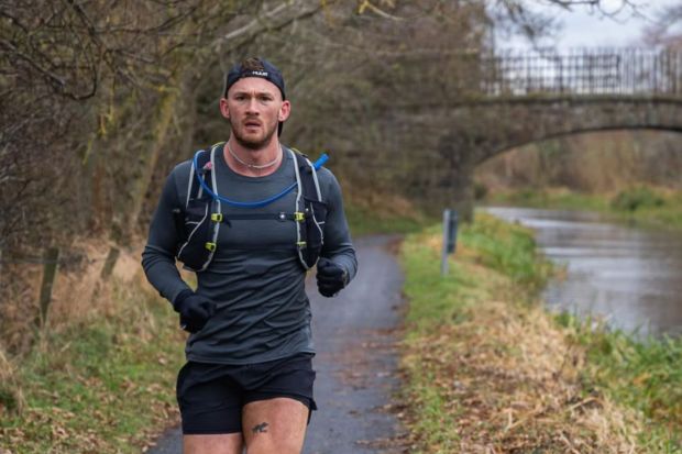 Man trail running along a canal.