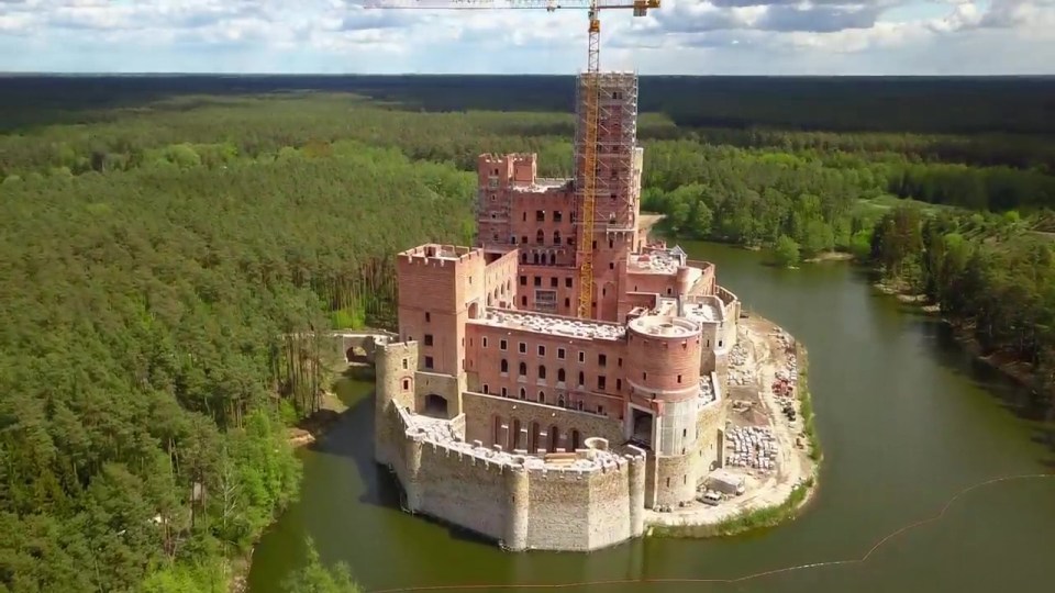 Aerial view of Stobnica Castle under construction on a man-made island.